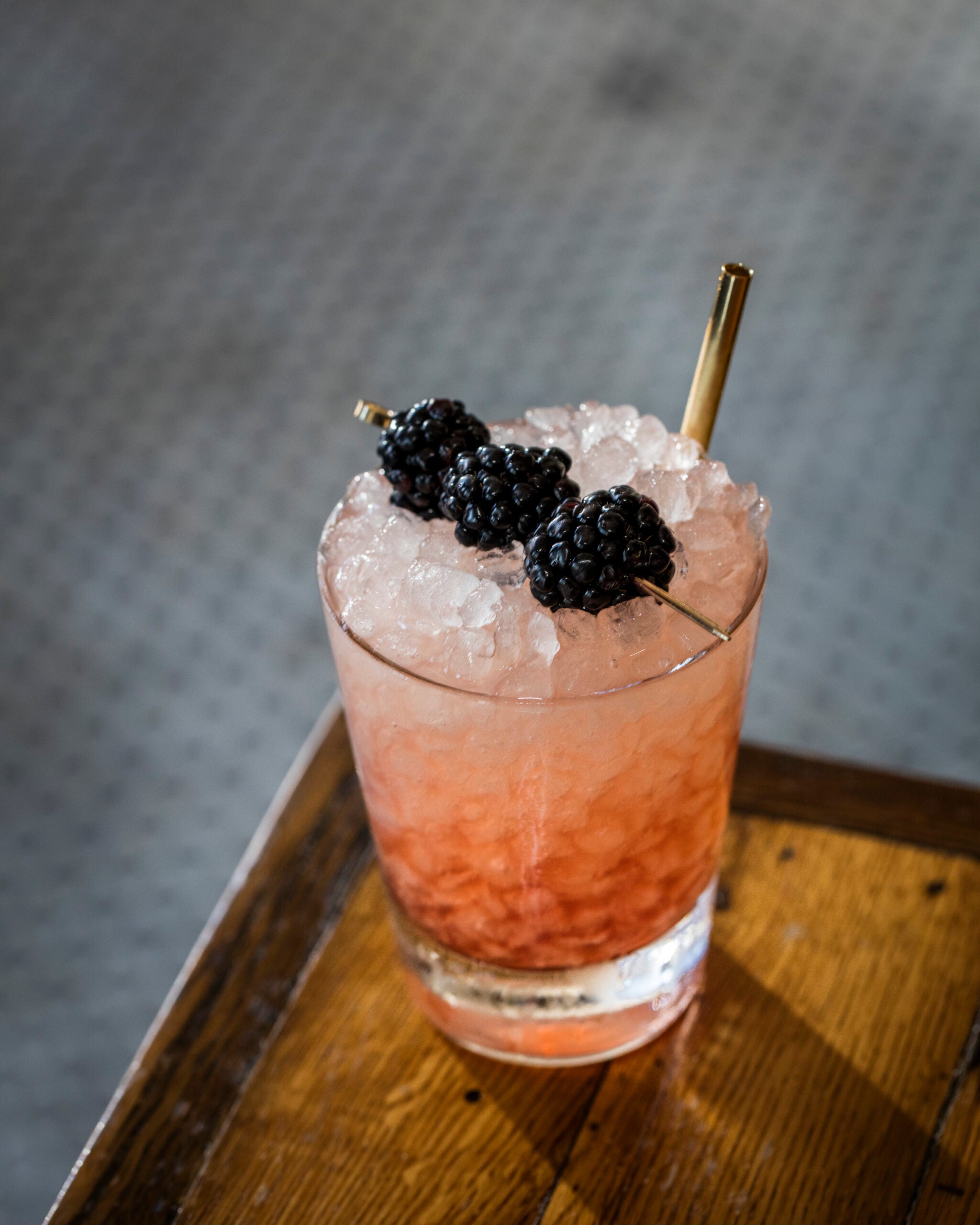Bramble cocktail topped with blackberries.